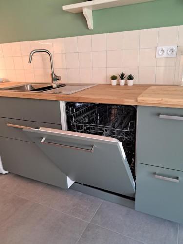an empty dishwasher in a kitchen with a sink at Stable Cottage at Le Prieuré in Mantilly