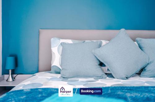 a bed with blue and white pillows on it at Spacious Detached Bungalow By Harperletting Short Lets & Serviced Accommodation Buckely With Pool table & Driveway in Buckley