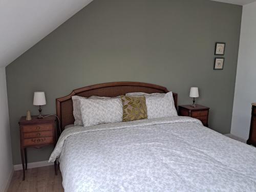 a bedroom with a large bed with two night stands at Stable Cottage at Le Prieuré in Mantilly