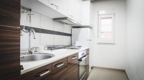 a small kitchen with a sink and a window at Nice Apartment in Gevgelija