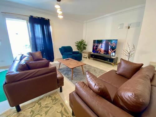 a living room with two couches and a tv at Luxe Home in Madinaty in Madinaty