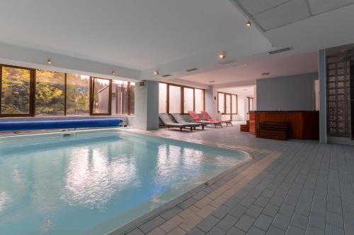 a large swimming pool in a room with windows at Vila Pinul si Mesteacanul in Poiana Brasov