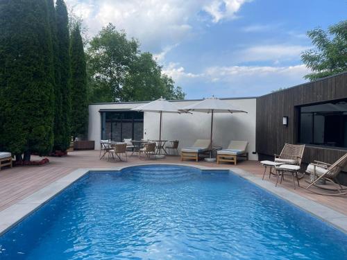 a swimming pool with chairs and tables and umbrellas at Forest 1961 Boutique Hotel & Restaurant in Vanadzor