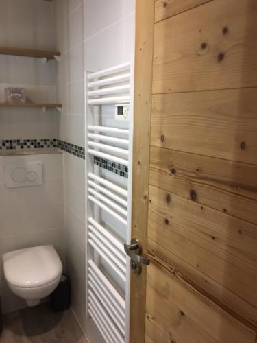 une salle de bain avec toilettes et porte en bois dans l'établissement Studio cabine à La Clusaz avec garage, à La Clusaz