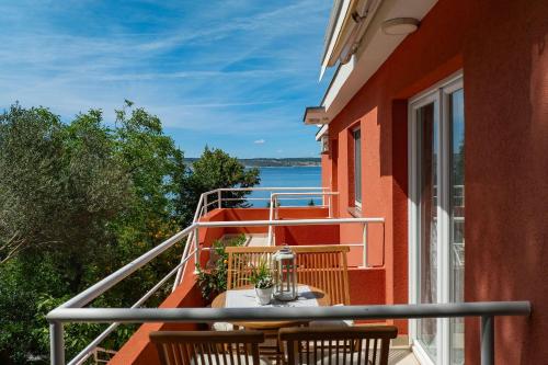 a balcony with a table and chairs and a view of the water at Candela, No 3 in Starigrad-Paklenica