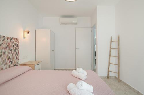 a bedroom with a bed with towels on it at Apartamentos Bellamar in Barbate