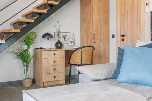 a bedroom with a bed and a desk and a staircase at Argeno Suites Lefkada in Lefkada Town