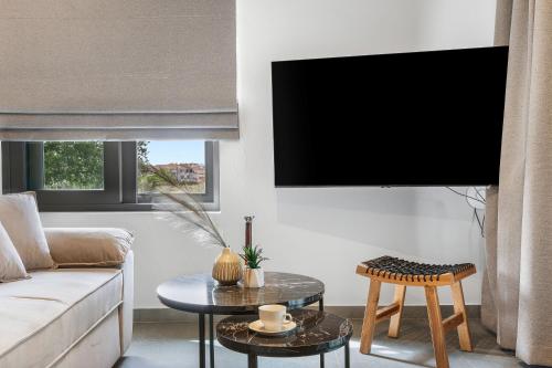 a living room with a couch and a flat screen tv at Argeno Suites Lefkada in Lefkada Town