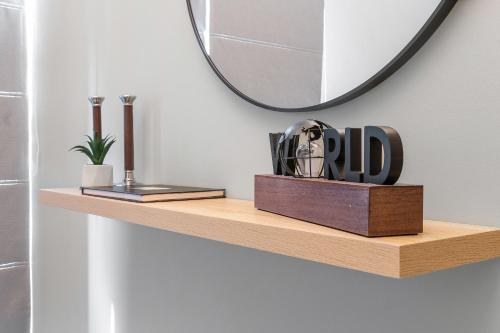 a wooden shelf with a mirror on a wall at Argeno Suites Lefkada in Lefkada Town