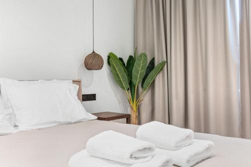 a bedroom with white towels on a bed at Argeno Suites Lefkada in Lefkada Town