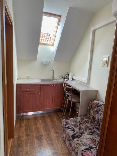 a kitchen with a couch and a sink and a window at Penzion Olga Hajasova in Bojnice