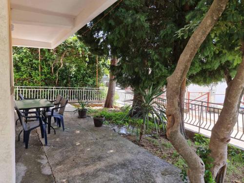 a patio with a table and chairs and trees at Apartmani S in Zgrada