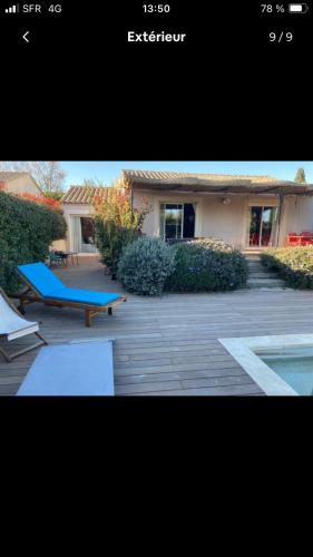 une photo d'une maison avec un banc bleu dans l'établissement Villa à 10mn de St Rémy de Provence, à Maillane