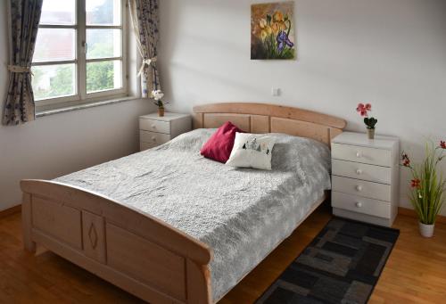 NadgoricaApartments Sina的卧室里有一张木床，配有两个枕头