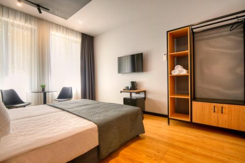 a bedroom with a bed and a flat screen tv at Smart Rooms in Varna City