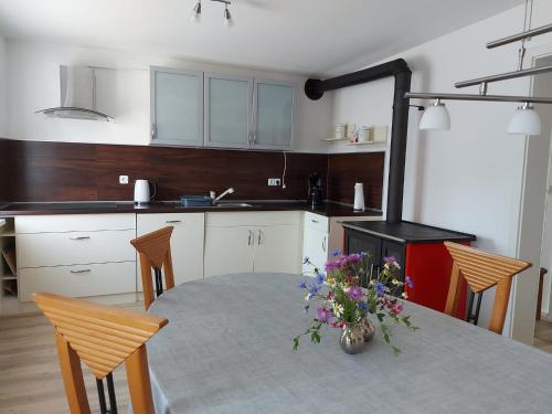 a kitchen with a table with a vase of flowers on it at Ferienwohnung Josy in Memmelsdorf