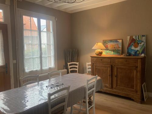 une salle à manger avec une table et des chaises et une fenêtre dans l'établissement Saint exupery, à Offranville