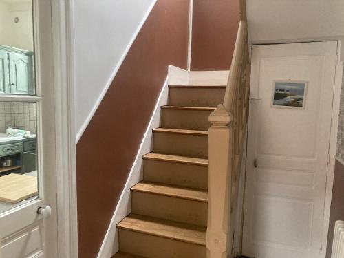 a staircase in a home with a white door at Saint exupery in Offranville