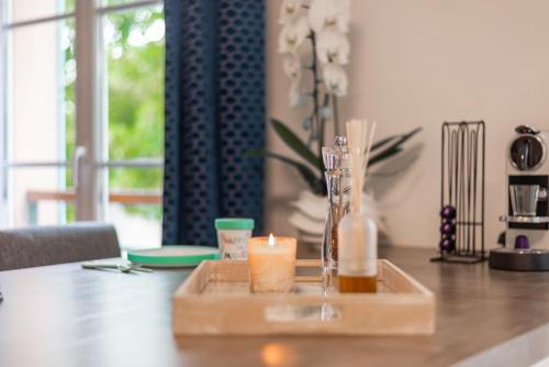 - un plateau en bois avec deux bougies sur une table dans l'établissement CM - Le cocon des Champs à 10 min de Disneyland Paris, à Serris