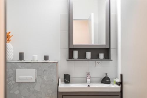 une salle de bain avec un lavabo et un miroir dans l'établissement CM - Le cocon des Champs à 10 min de Disneyland Paris, à Serris