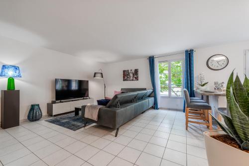 un salon avec un canapé et une télévision dans l'établissement CM - Le cocon des Champs à 10 min de Disneyland Paris, à Serris