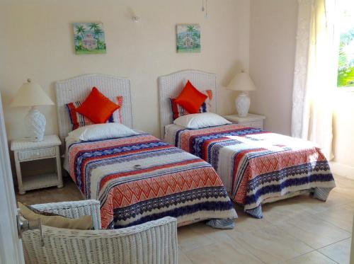 1 dormitorio con 2 camas con almohadas de color naranja en Remarkable 3-Bed Villa in christ church, en Christ Church