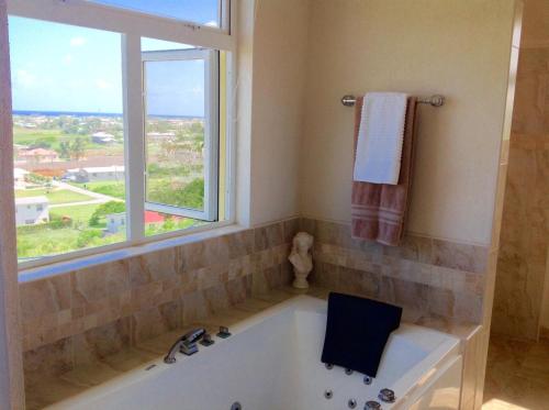 una bañera en un baño con ventana en Remarkable 3-Bed Villa in christ church, en Christ Church