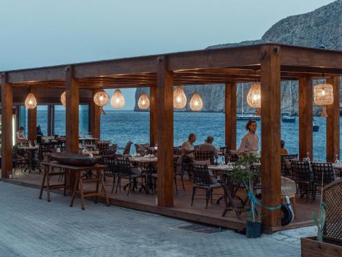 a restaurant with tables and chairs and a view of the water at KaSeas Boutique Hotel in Gerolimenas