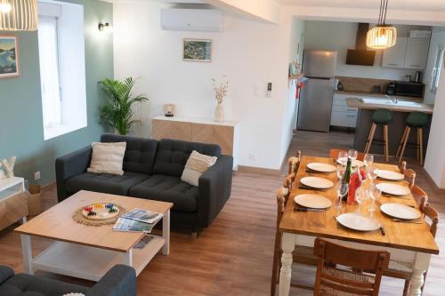 un salon avec une table et un canapé dans l'établissement Jolie maison entièrement rénovée proche du bourg et des plages, à Landéda