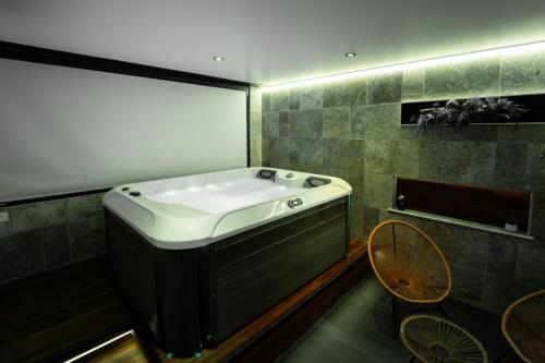 a bathroom with a bath tub and a table and chairs at Loft 150 m2 Jacuzzi, Sauna et Massage in Blagnac