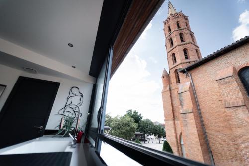 a view of a church tower from a window at Loft 150 m2 Jacuzzi, Sauna et Massage in Blagnac