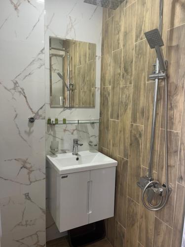 a bathroom with a white sink and a mirror at Стаи за гости Бела in Ahtopol