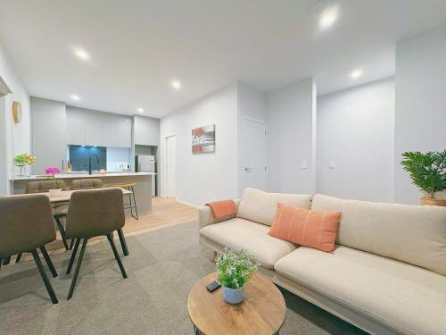 a living room with a couch and a table at Modern & Stylish 3 Bedroom at lowerhutt in Lower Hutt
