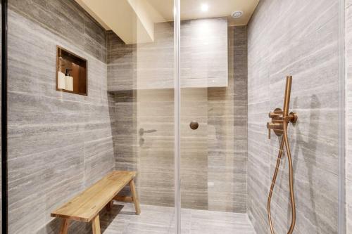 La salle de bains est pourvue d'une douche avec un banc en bois. dans l'établissement Luxurious Property - 3BR-8P - Saint Germain, à Paris