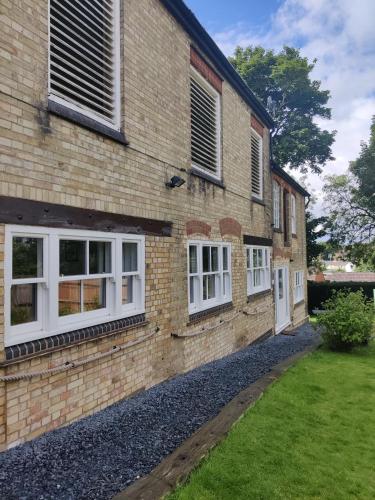 a brick house with white windows and a yard at The Old Rope Works in Woburn Sands