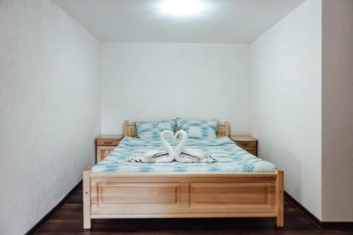 a bed with a wooden frame in a room at Guesthouse Juli in Sapareva Banya