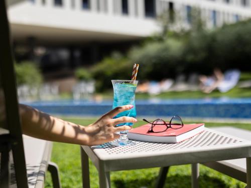 a person sitting at a table with a drink at Hotel Salona Palace in Solin