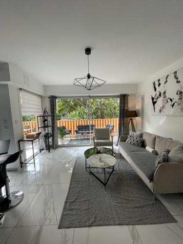 un salon avec un canapé et une table dans l'établissement Oasis by L'Oliveraie, à Cannes