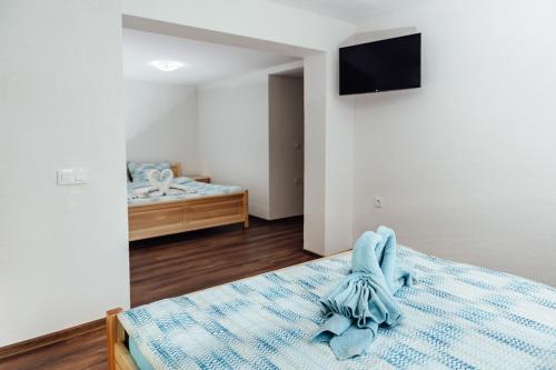 a bedroom with a bed with a tv on the wall at Guesthouse Juli in Sapareva Banya