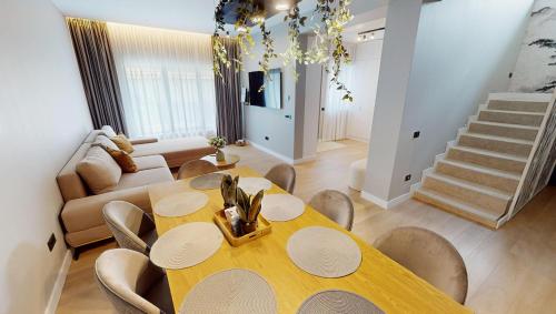 a dining room with a yellow table and chairs at Casa de vacanta Cris 2 in Băile Olăneşti