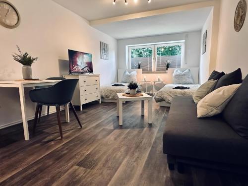 a living room with a couch and a desk at Apartment Burgkeller Idyllisch & Ruhig in Bad Bentheim
