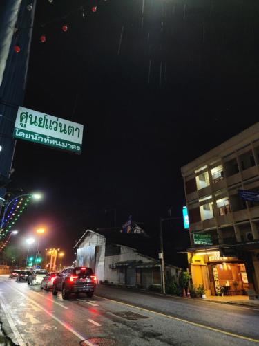 eine Straße in der Nacht mit Autos auf der Straße in der Unterkunft Yamawa Guest House ยามาวาเกสเฮ้า in Trang