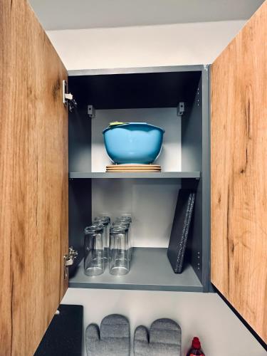 a cupboard with a blue bowl on a shelf at Apartment Burgkeller Idyllisch & Ruhig in Bad Bentheim