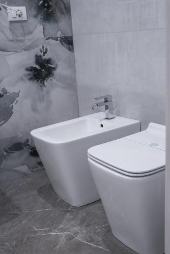 a white toilet and a sink in a bathroom at La Peonia B&B in Ragusa