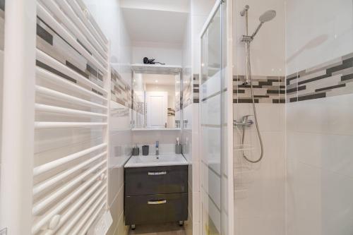 une salle de bain blanche avec un lavabo et une douche dans l'établissement Appartement Bandjoun - Pour 4 à Mulhouse, à Mulhouse