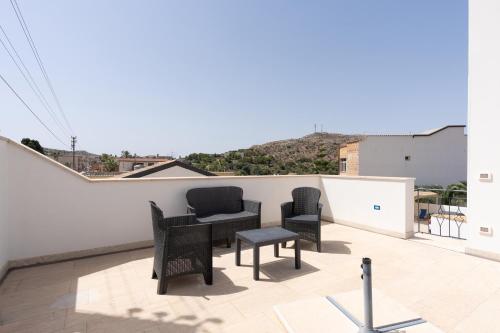 a patio with two chairs and a table on a roof at Cuore di Conchiglia 3 in Custonaci