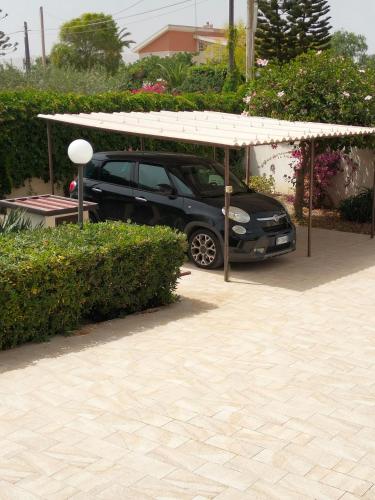 a car parked under a pavilion in a driveway at A Casa Mia in Butera