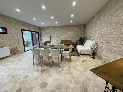 un salon avec une table et des chaises dans l'établissement La petite Maison en Normandie, à Muids