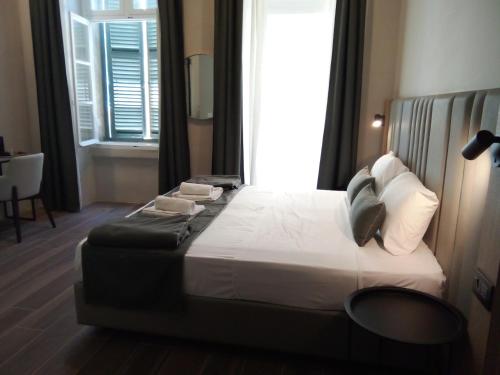 a bedroom with a large bed with a window at Mulberry Suites in Valletta