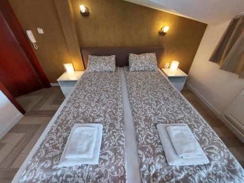 a large bed in a small room with two tables at Jovanovic Guest House in Ohrid